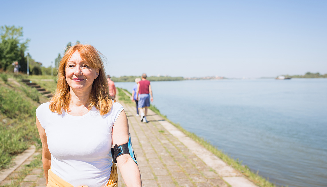 Mature  woman having walking on a trail by water
