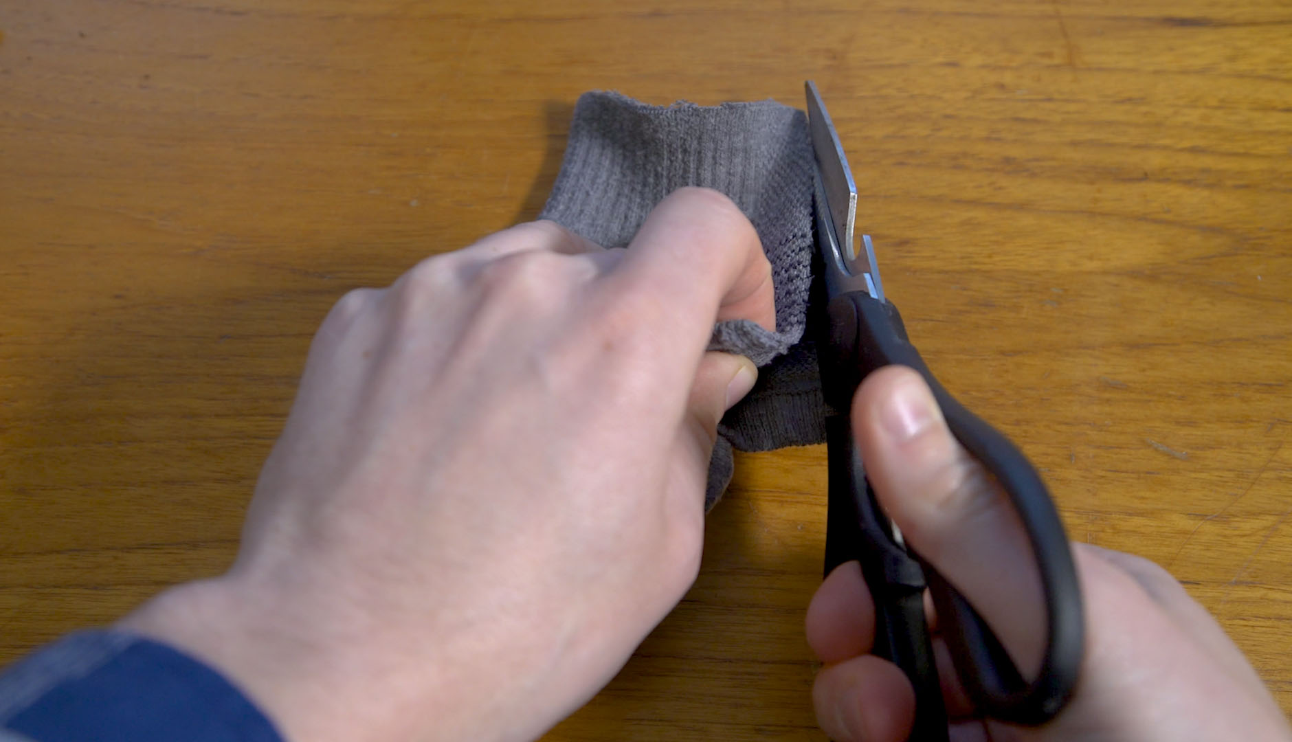 hands cutting folded sock