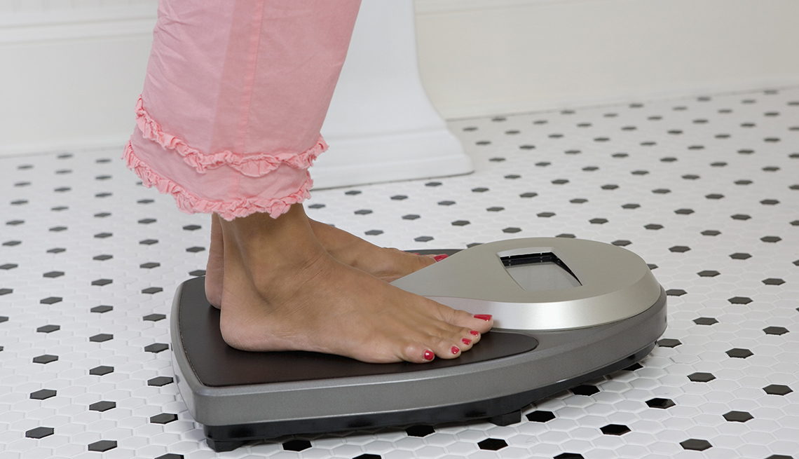 view of a womans feet on a scale weighing herself