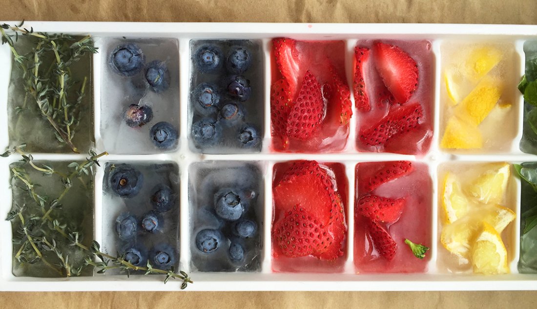 assorted fruit and herbs frozen in an ice cube tray