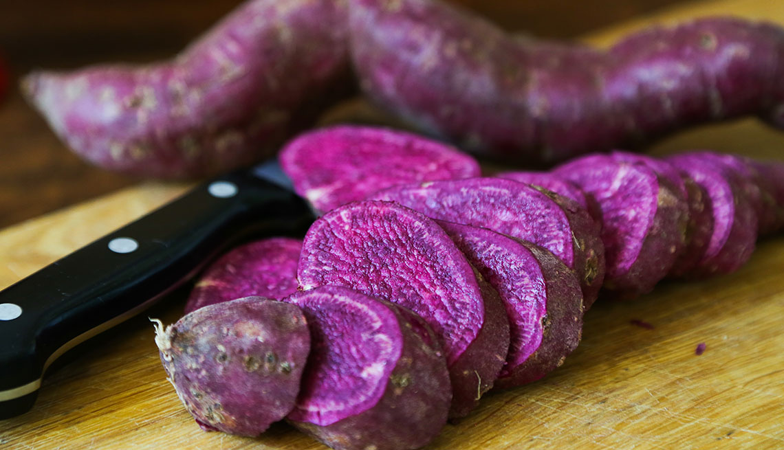 sliced purple sweet potatoes on cutting board