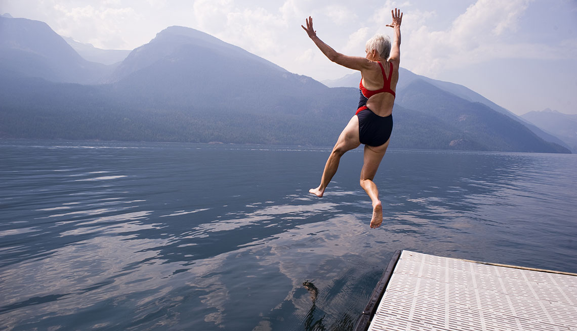 woman jumping into a lake