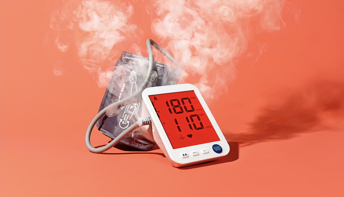 Un monitor de presión arterial que muestra números altos y sale humo como si se quemara