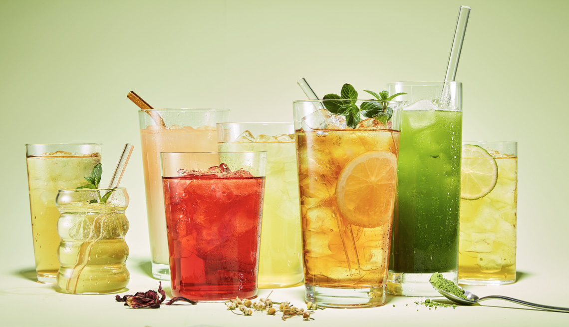 ice teas of various colors and flavors arranged with ingredients