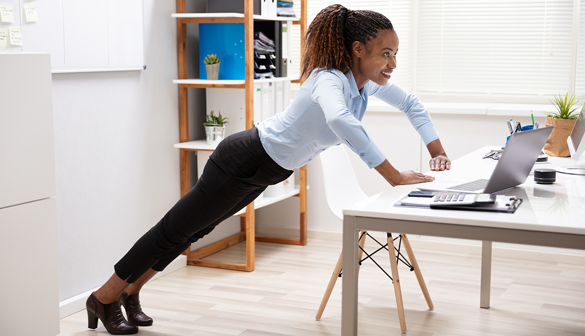 woman doing pushups at her desk at work
