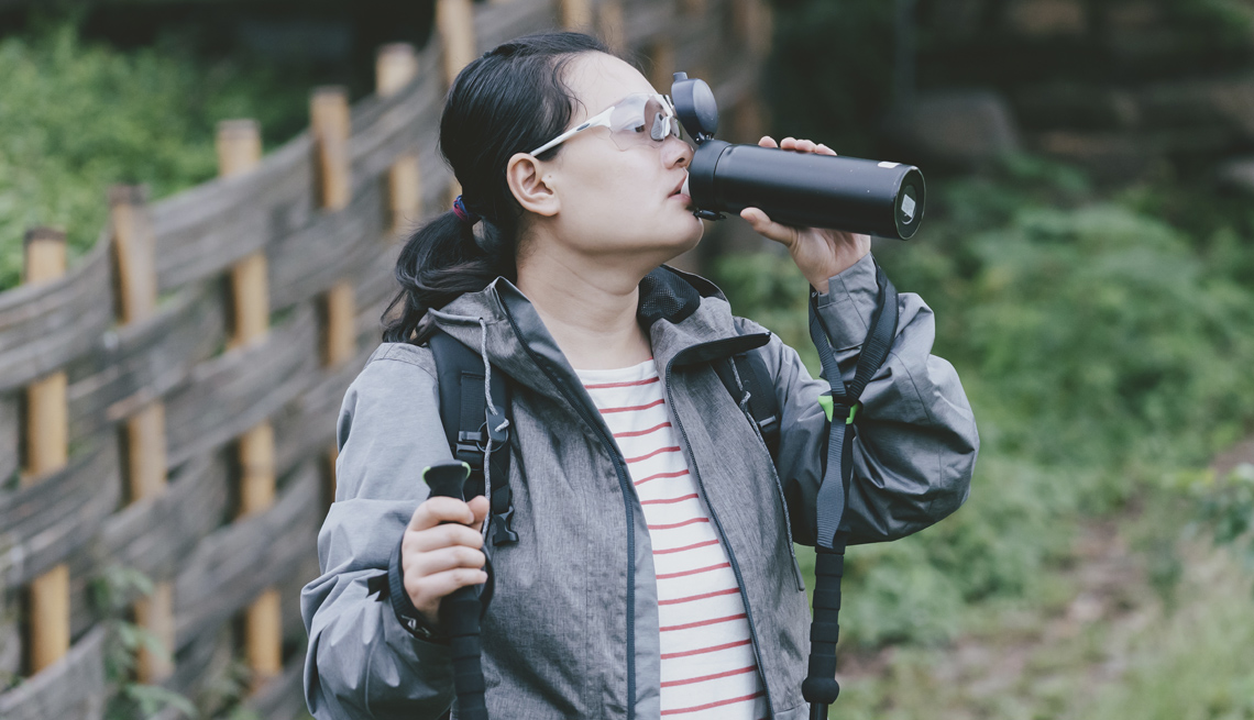 woman hiking drinking water