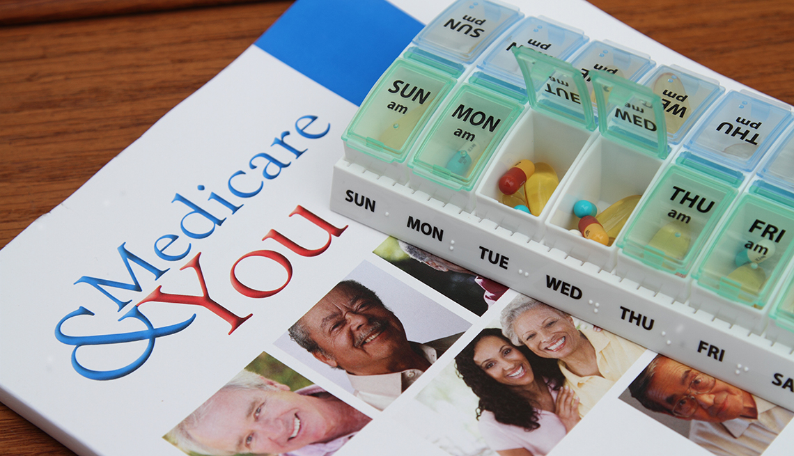 Medicare & You booklet laying on a table. A weekly reminder pill box sits on top. 