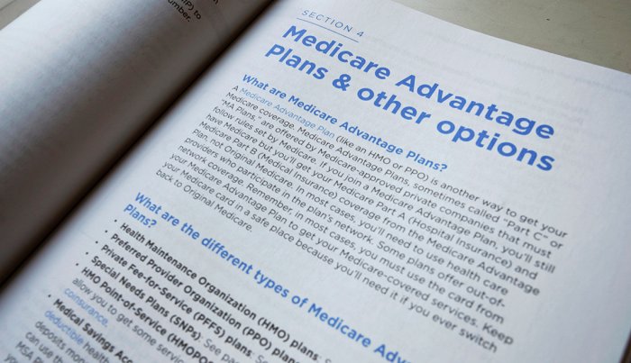 A 2019 U.S. Medicare Handbook is open showing a page on Medicare Advantage plans and other options