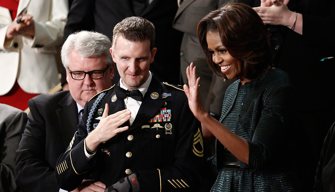 Craig Remsburg, izquierda, con su hijo, el sargento del ejército  de primera clase Cory Remsburg y la primera dama Michelle Obama en el discurso del Estado de la Unión del Presidente Barack Obama en Washington, DC