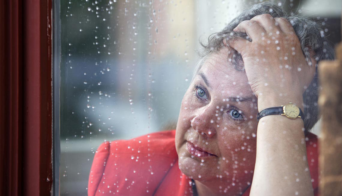 Mujer con actitud de preocupación al frente de una ventana - El matrimonio y el cuidado de los cónyuges