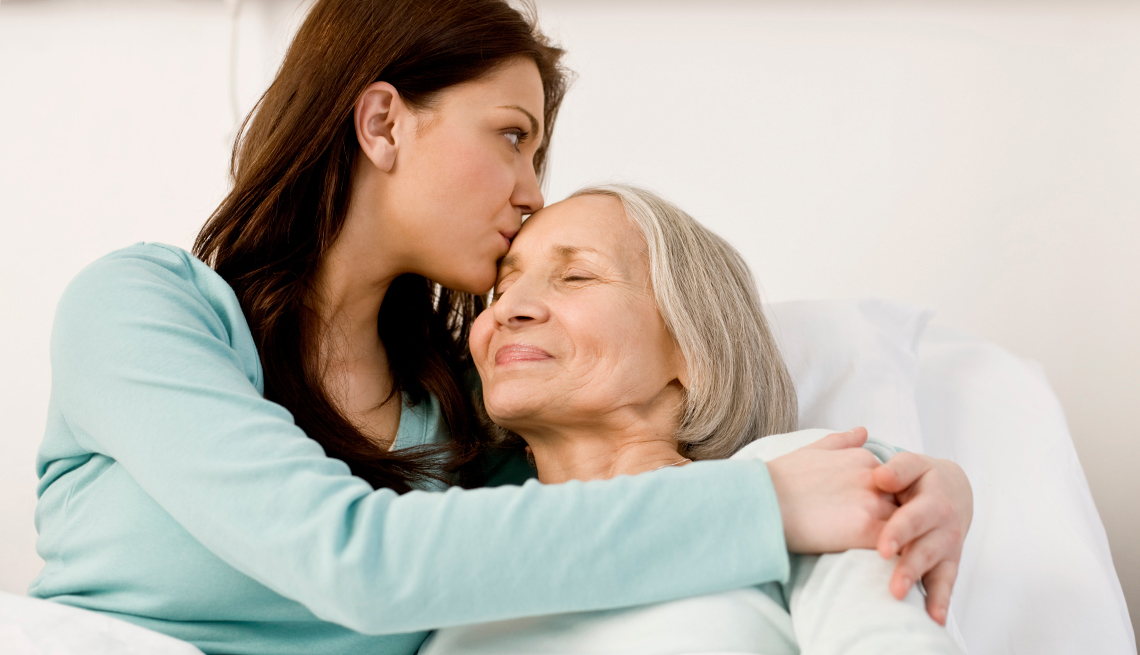 Cuidar de un ser querido es una labor costosa - Mujer joven abraza a una mujer mayor