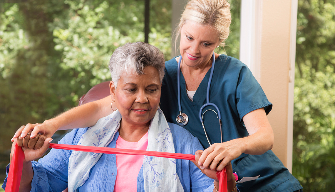 Un profesional médico trabaja con un paciente mayor durante la fisioterapia.