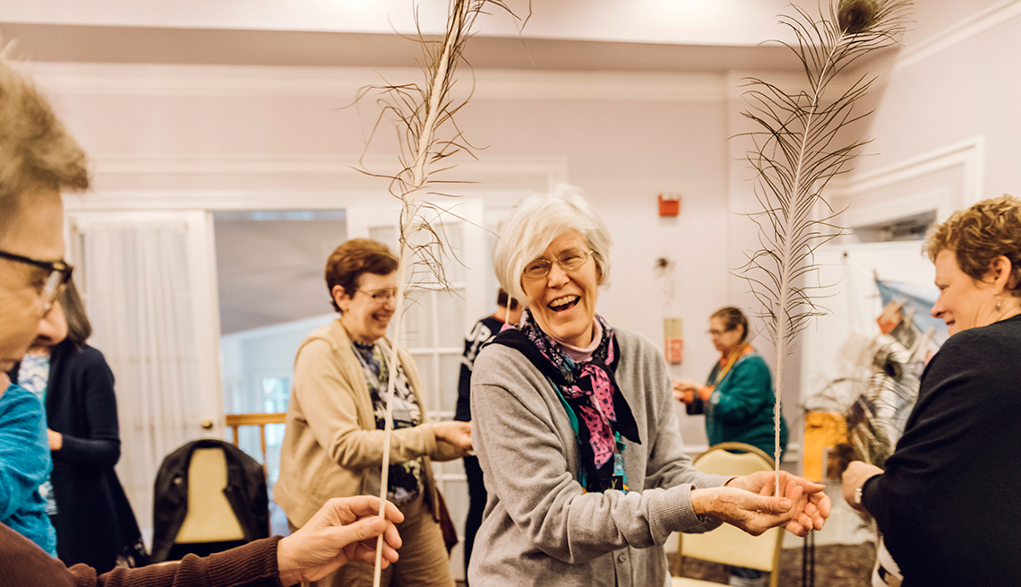 Mary Herbers, center, participates in a group activity about balance with peacock feathers during the Caring for the Caregiver retreat held at Rockwood Manor in Potomac, Maryland. 