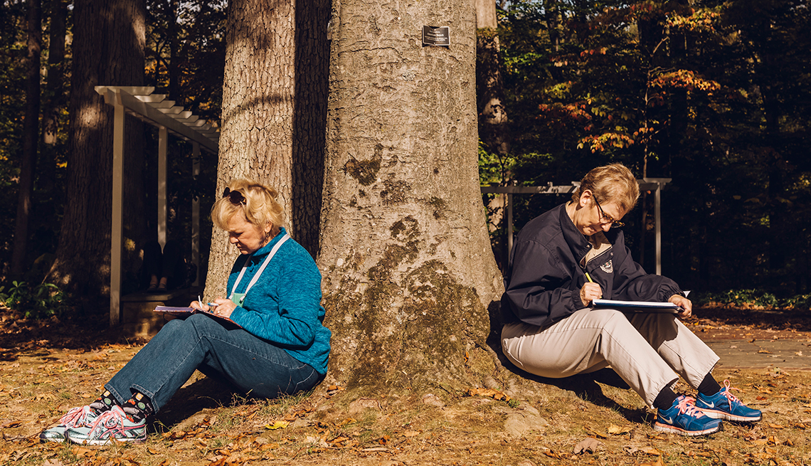 Kathryn Schafer, left, and Bonnie Adams, right, participate in a nature-based exercise about being present in one's emotions during the Caring for the Caregiver retreat 