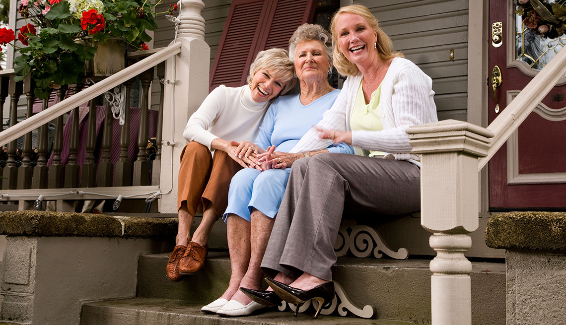 Tres mujeres de diferentes edades sentadas en una escalera