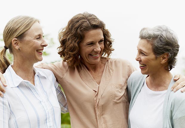 Tres mujeres sonriendo y abrazándose - ¿Por qué los hombres deberían salir con mujeres de su misma edad?