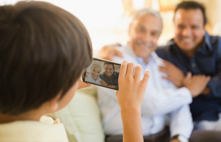 Un niño toma una foto de su padre y su abuelo. Cómo crear historias familiares orales.