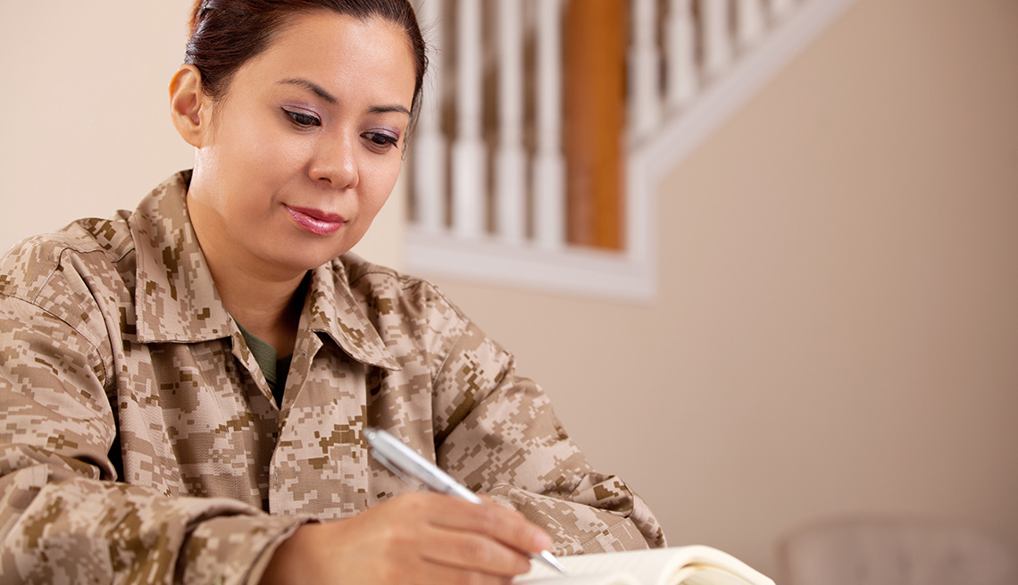 Beneficios de educación para veteranos y sus familias - Mujer sentada observa un libro