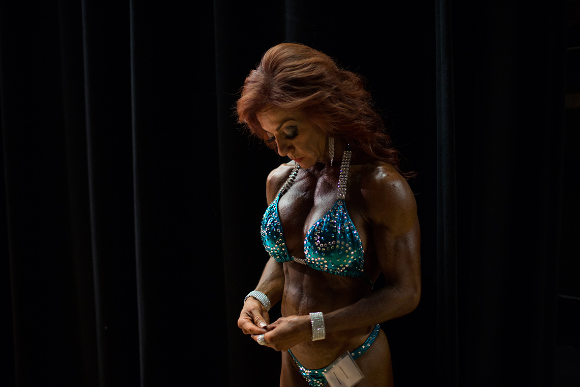 item 7 of Gallery image - Sherry has a quiet moment to herself backstage at a competition in East Orange, New Jersey. At this show, Sherry received her pro card with the National Gym Association, an all natural organization.