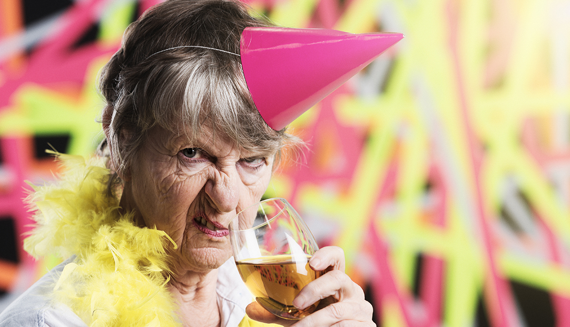 item 4 of Gallery image - Mujer mayor hace una cara gruñona mientras bebe vino.