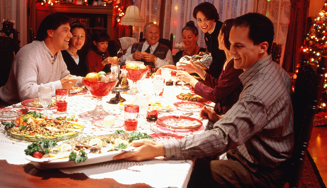 A family sitting around a dinner table having a holiday meal.