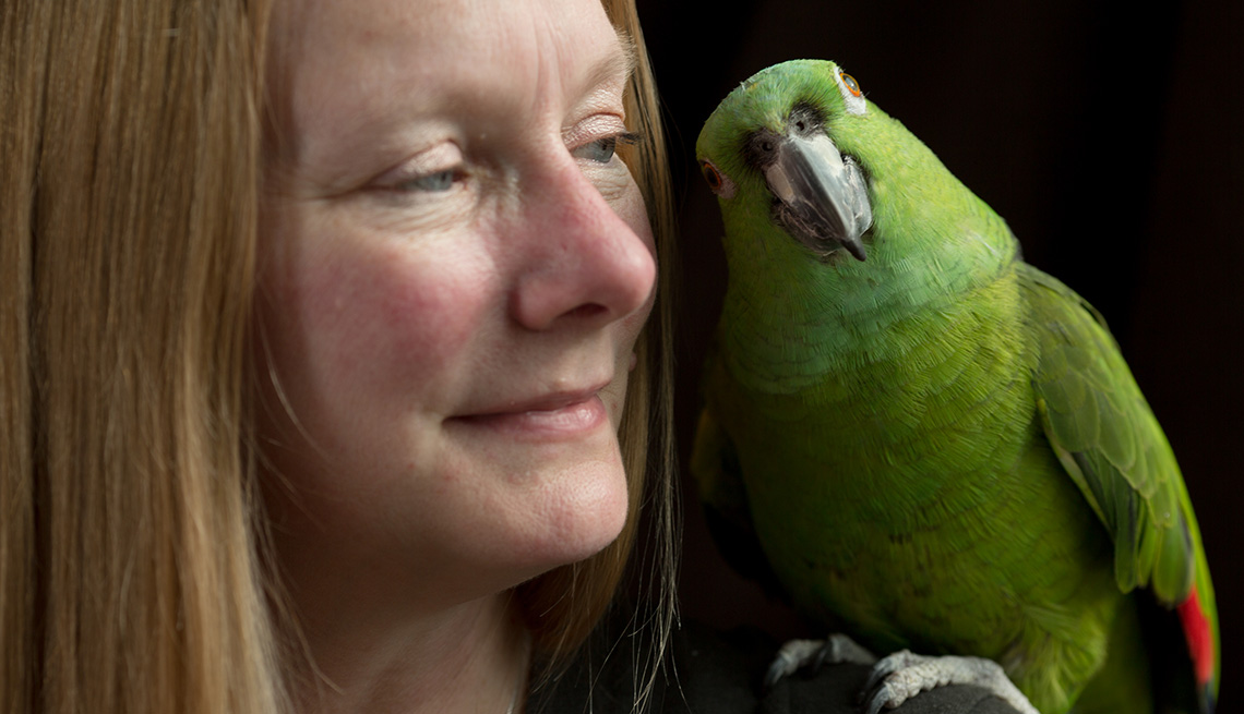 item 2 of Gallery image - close up of woman with green parakeet on her shoulder