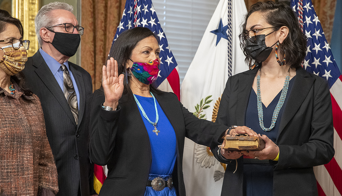 Deb Haaland, U.S. secretary of the interior, second left, reacts during a swearing in ceremon