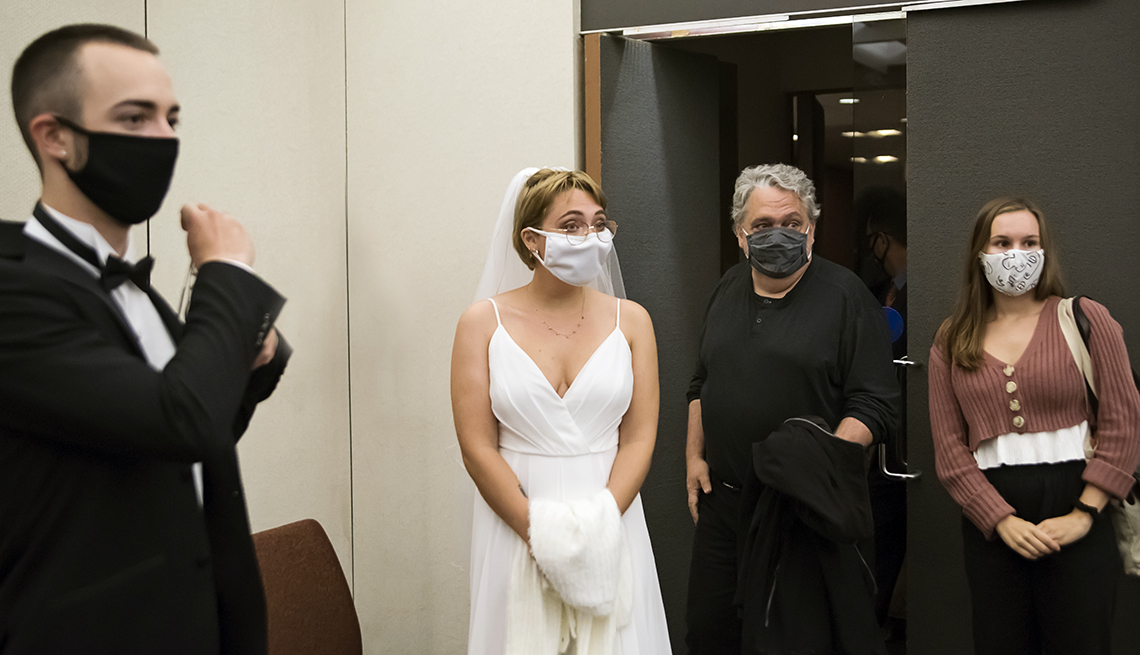 young couple wearing face masks getting ready to walk into their wedding ceremony