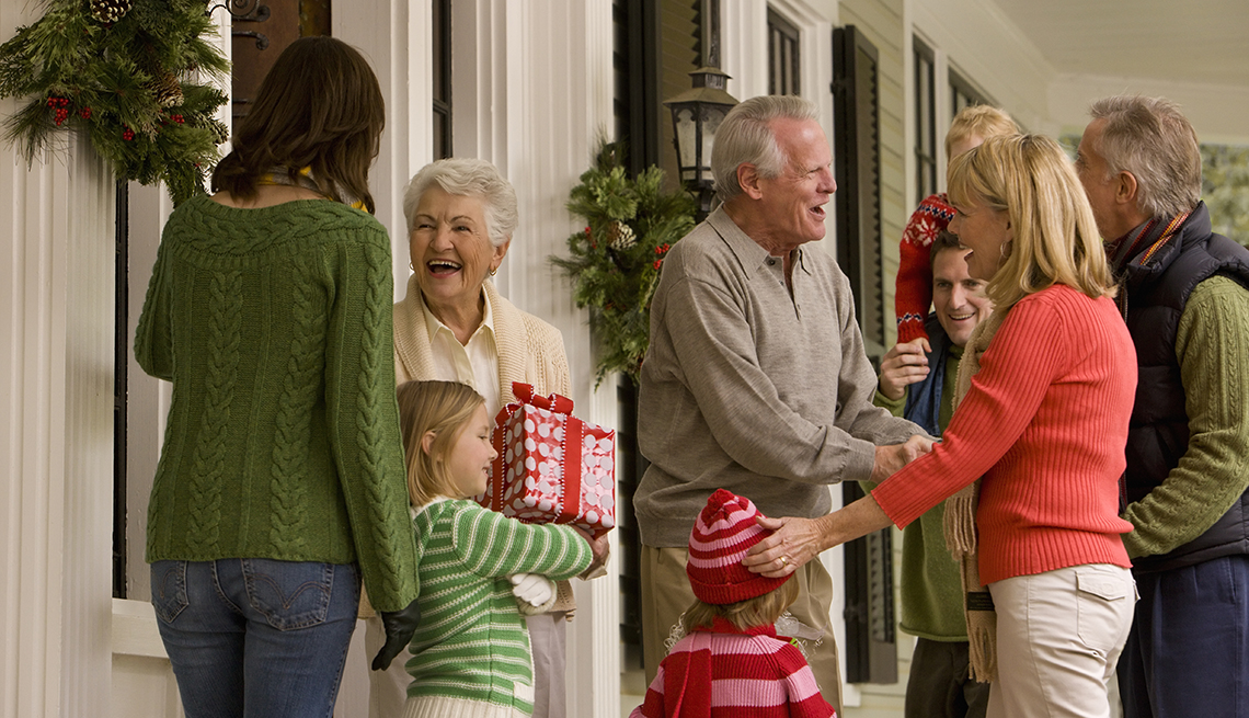 a family greeting each other at christmas on their front porch