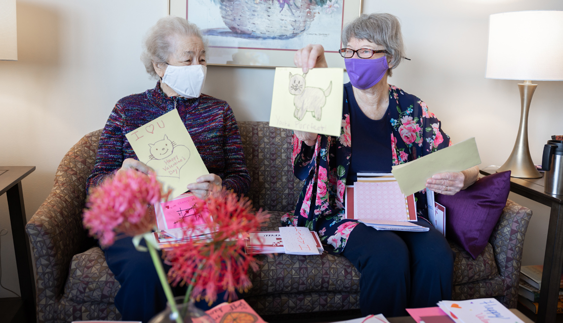 Dos mujeres mayores Christine Baker y Lyn Nelson sostienen una tarjetas hechas a mano