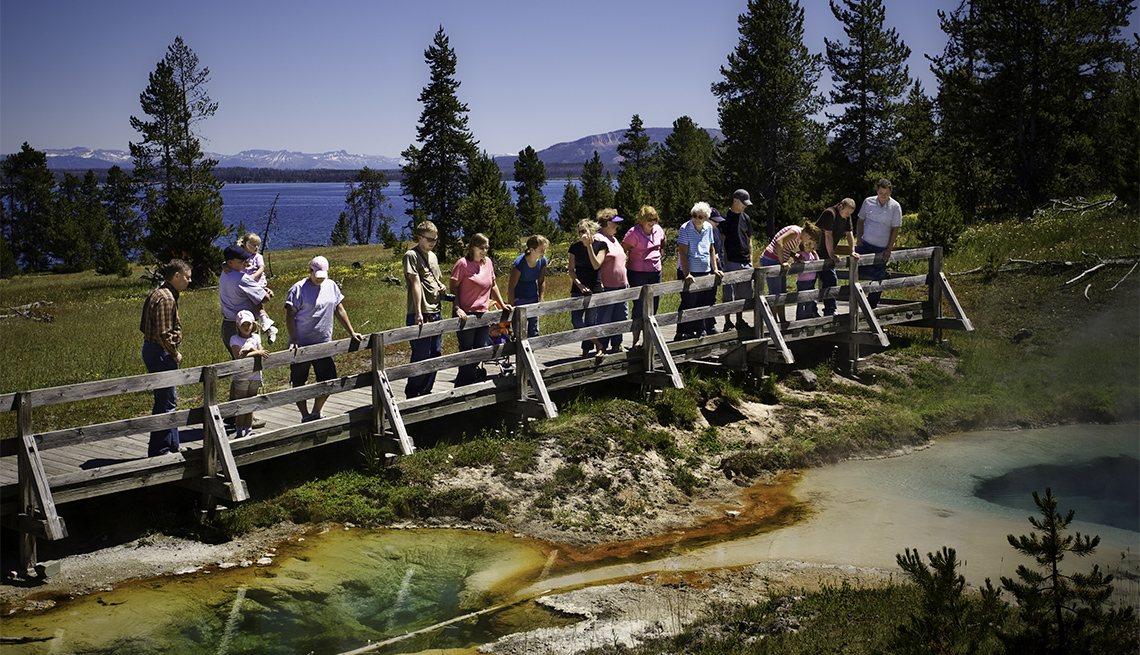 A family vacation as they all stand around veiwing the hot pots of Yellowstone National Park