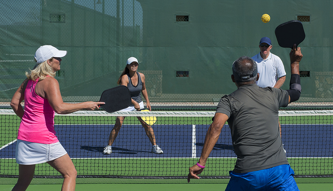 two couples playing a game of pickleball