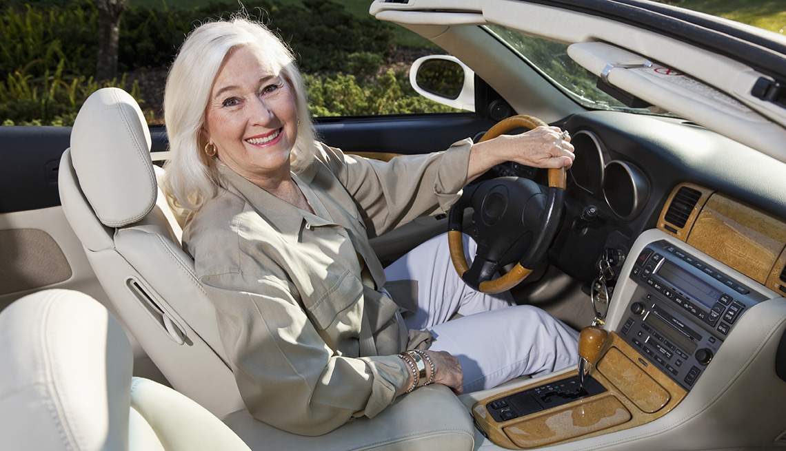 Mujer mayor sentada en su auto