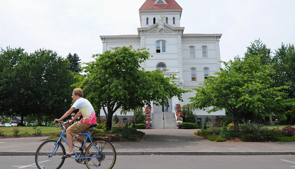 Bicyclist rides by building in downtown Corvallis Oregon.