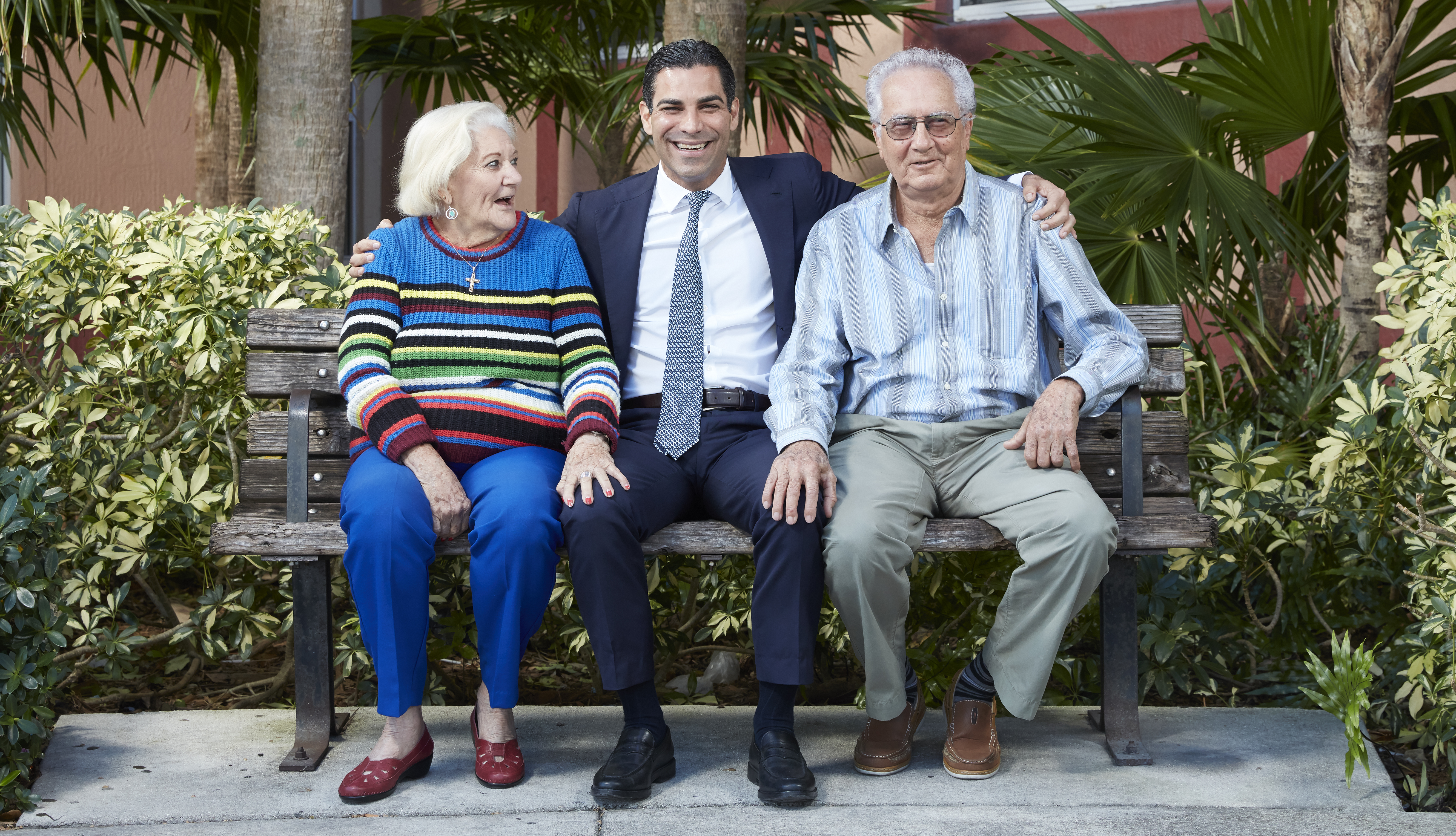 miami florida mayor francis suarez sits on a bench outside an apartment building with two residents