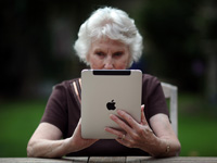 Cómo pasar la información digital fotos, mensajes de texto y correos electrónicos a sus herederos-una mujer mayor usa su iPad