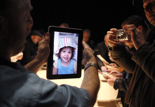 Un hombre prueba la exhibición de fotos sobre un nuevo iPad.