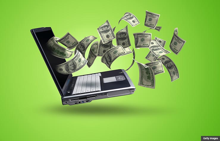 Money flying out from a computer screen, How to Make Money with Old Gadgets and Electronic (Getty Images)