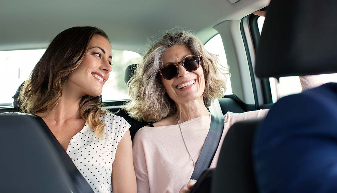 Dos mujeres hablan mientras van en un auto - Cómo te benefician los servicios de auto compartido