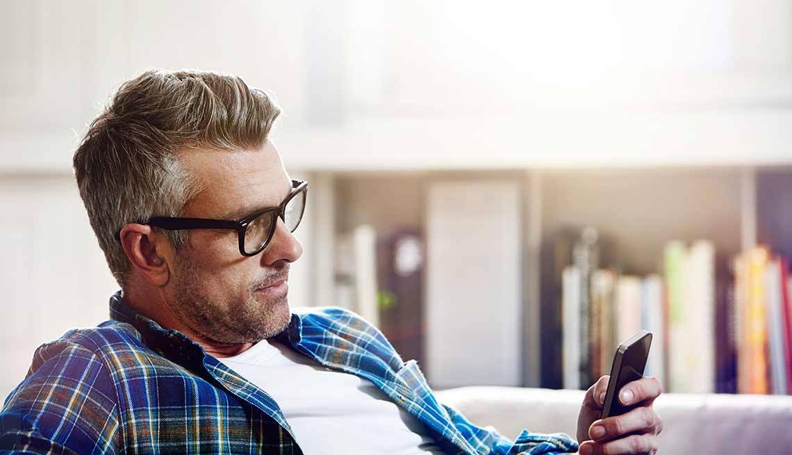 Cómo reducir el estrés con ayuda de apps - Hombre viendo pantalla de teléfono inteligente