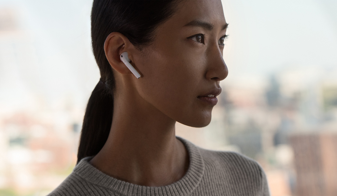 Mujer usa los audífonos Apple AirPod.