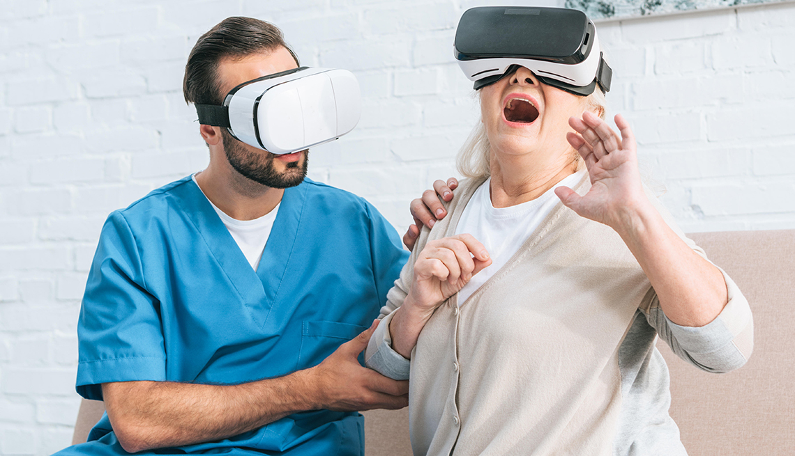 A woman looking through VR goggles, alongside a healthcare professional. 