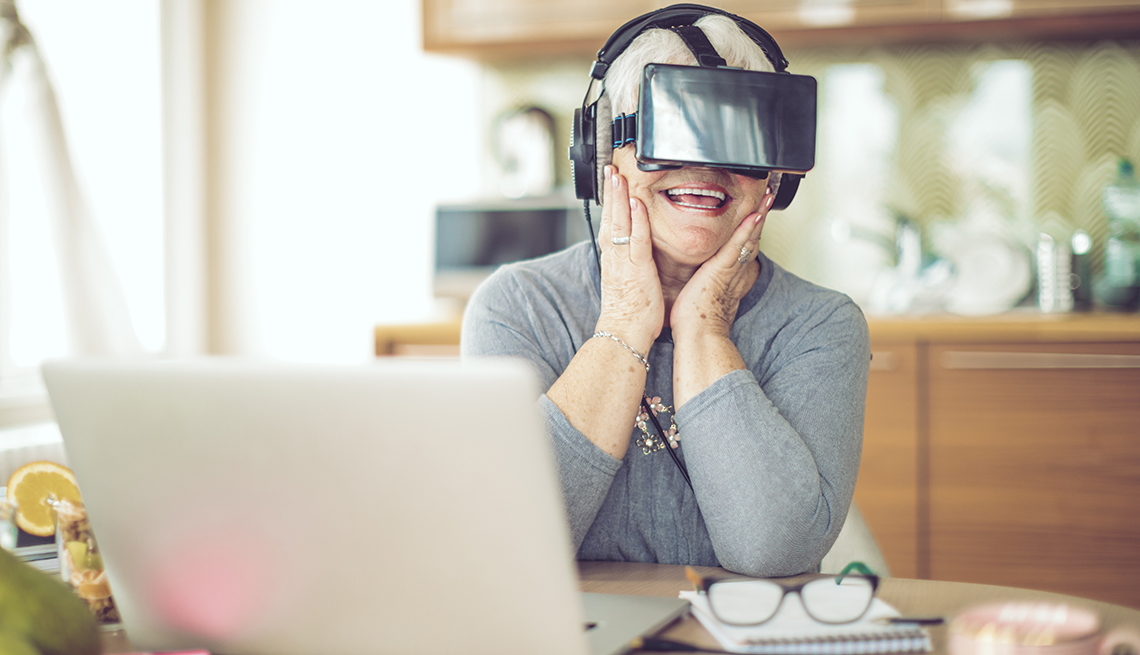 A woman wearing VR goggles at her kitchen table