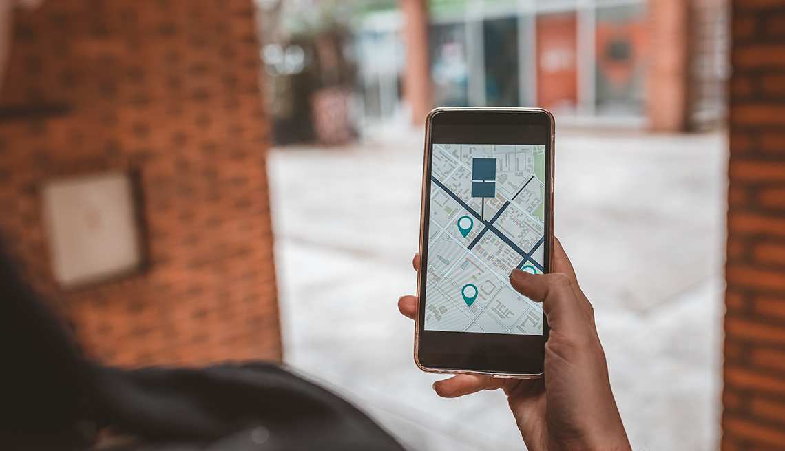 Persona usa el mapa en una aplicación del teléfono para navegar y encontrar su automóvil estacionado
