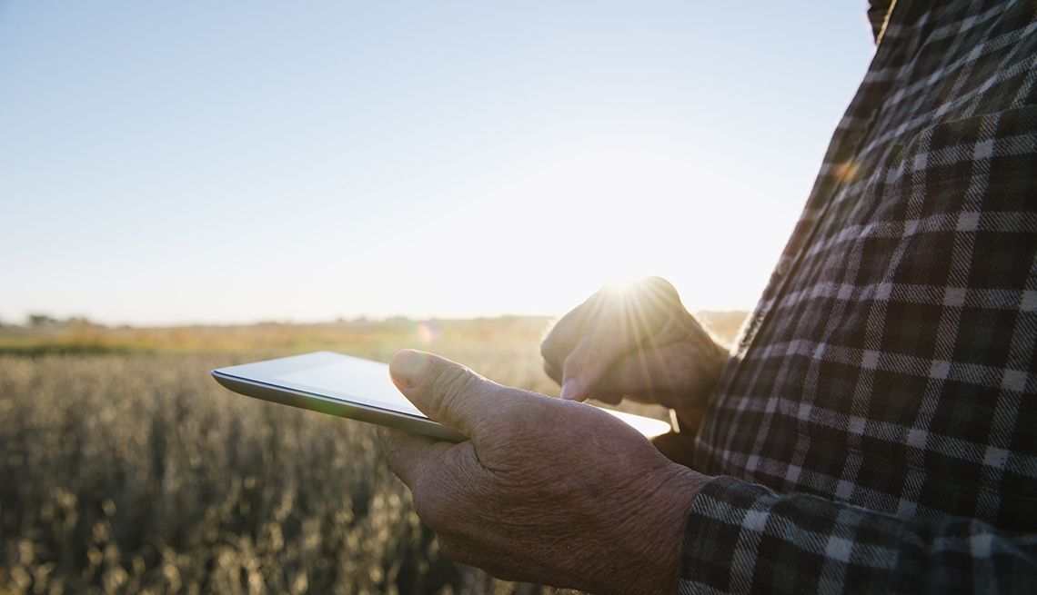 Man holding a tablet in a field