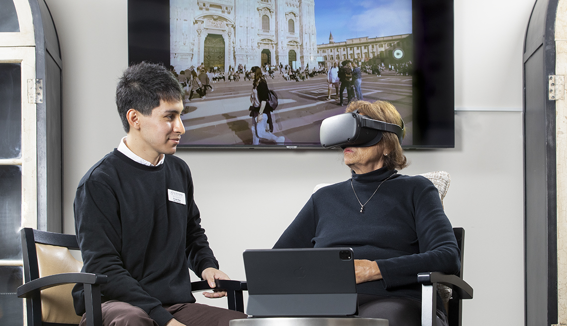 Frank Diaz en el Watermark de Napa Valley asiste a una mujer mayor con un visor de realidad virtual
