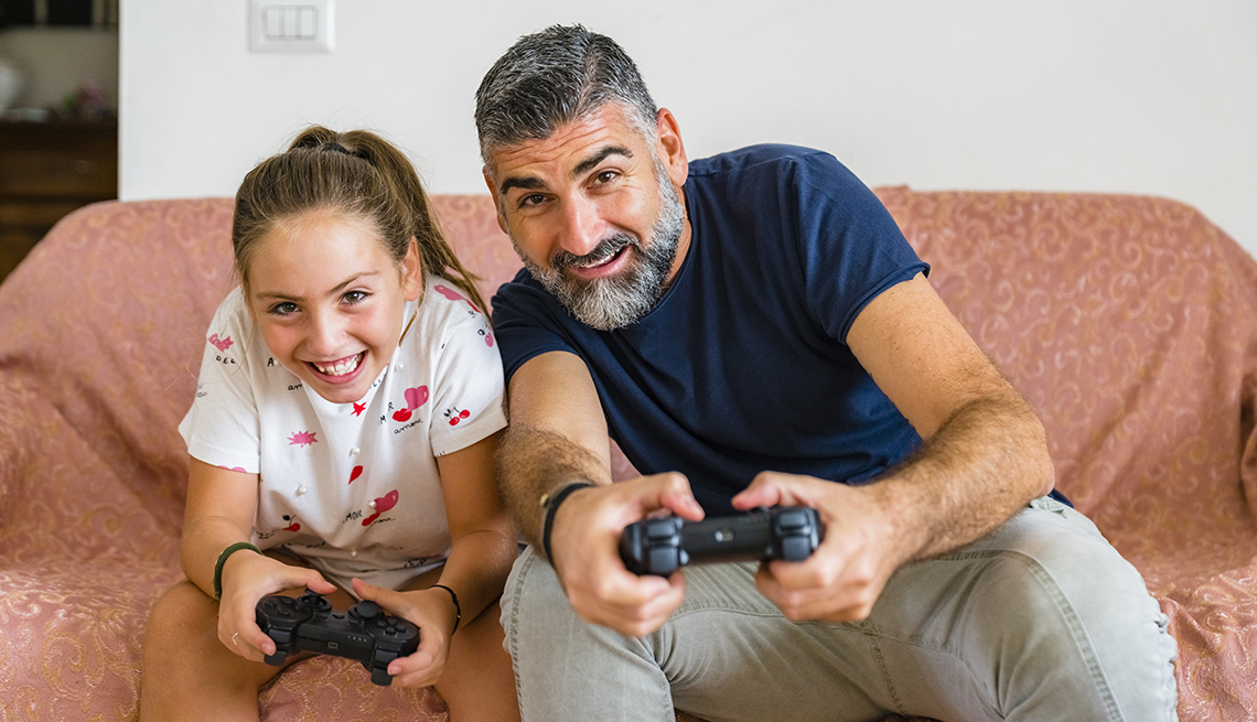 father and daughter playing video game together at home