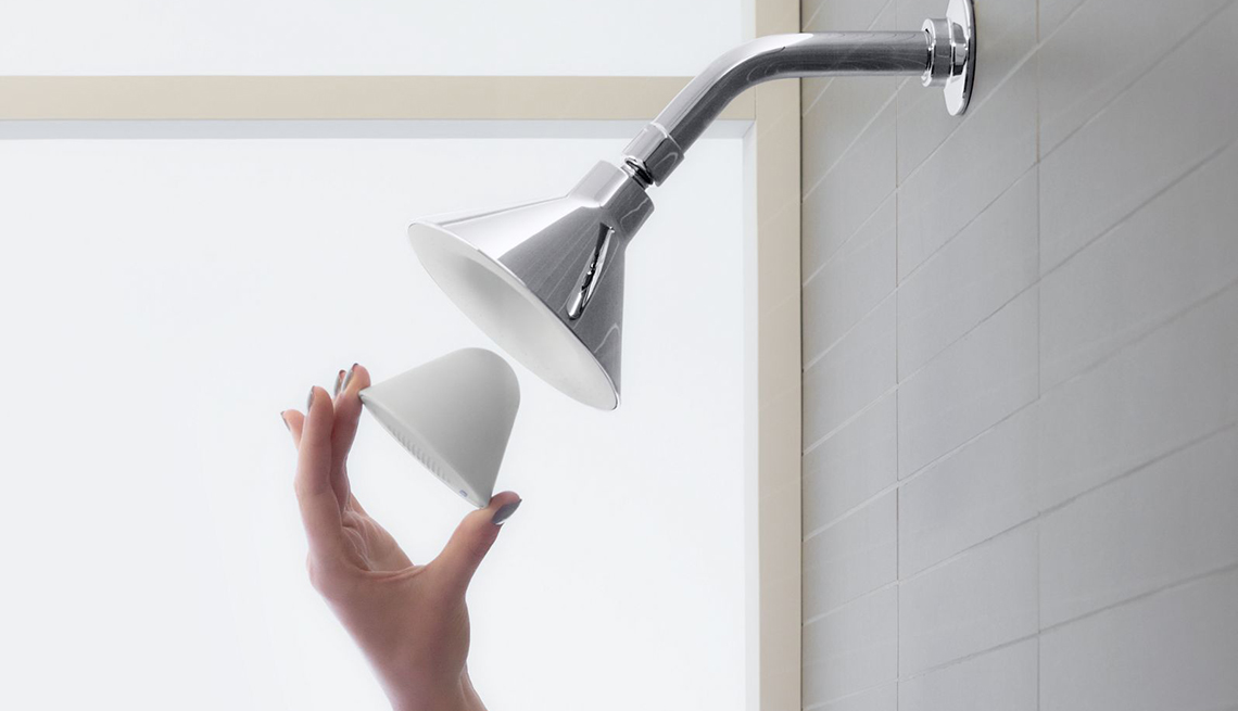 a person inserts a smart device into a shower head