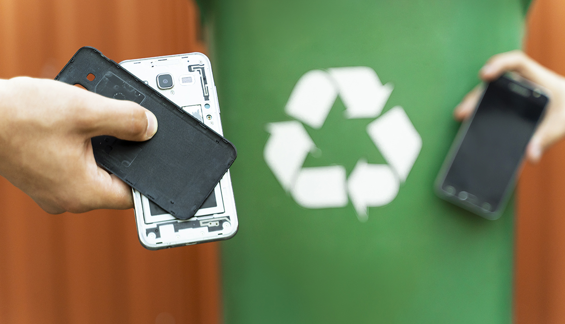two smartphones in front of a recycling bin