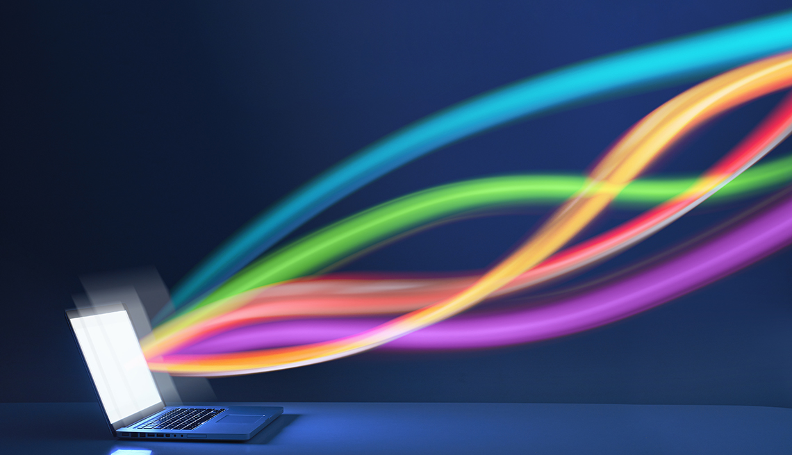 Cintas de colores que sugieren el flujo de transmisión de datos desde la pantalla de una computadora portátil